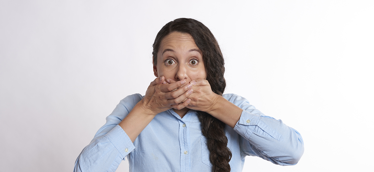 woman standing hands covering mouth